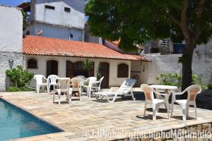 un grupo de sillas y mesas junto a una piscina en CASA 7 qts sendo 4 suites, Piscina Churrasqueira 200 m praia Anjos, en Arraial do Cabo