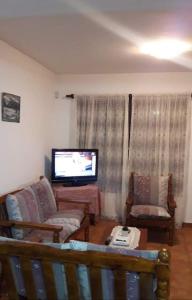 sala de estar con sofá y TV de pantalla plana en DUPLEX EN SAN BERNARDO en San Bernardo