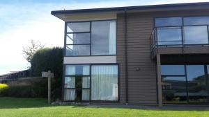 a house with glass windows on the side of it at Executive Home in Kaikoura