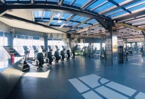 a gym with rows of exercise bikes and treadmills at Livefortuna Hotel in Beijing