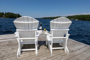 two white chairs and a table on a dock at Sherwood Inn in Port Carling