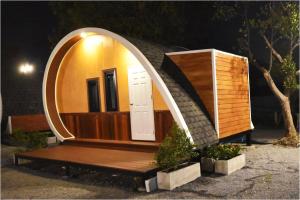 una piccola casa con una porta rotonda e una panca di legno di Tiny hut resort a Bangkok