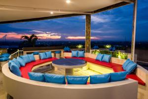 a living room with a table and blue chairs at Canggu Dream Village Hotel and Suites in Canggu