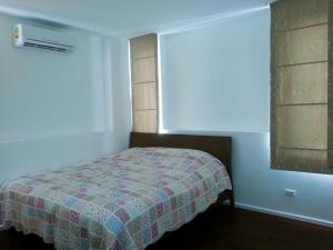 a bedroom with a bed with a quilt on it at Pool Villa PB6rayong in Rayong
