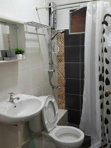 a bathroom with a toilet and a sink at GH Great Homes in Kuching