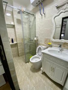 a bathroom with a shower and a toilet and a sink at Khanh Phong Apartment PG02-20 in Hai Phong +25 photos