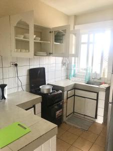 a kitchen with a stove and a sink at Bandari apartment in Mombasa