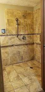 y baño con ducha y suelo de baldosa. en Econo Lodge San Antonio near SeaWorld - Medical Center, en San Antonio