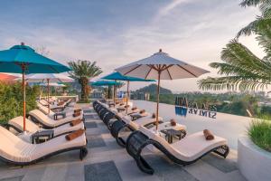 een rij stoelen en parasols in een resort bij Anda Sea Tales Resort-SHA Plus in Ao Nang Beach