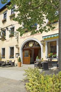 ein Gebäude mit Tischen und Stühlen davor in der Unterkunft Hotel BurgGartenpalais in Rothenburg ob der Tauber