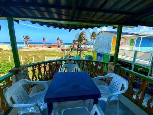 uma mesa e cadeiras numa varanda com vista para o oceano em Yellow Moon Guesthouse & Apartments em San Andrés