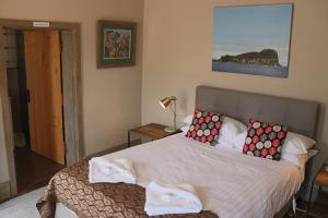 Un dormitorio con una cama grande con almohadas. en Robinson Cottage, en Oatlands