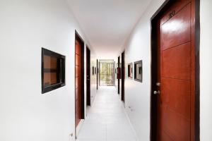 a hallway with wooden doors and white walls at ELTI DORMITEL by BLUEBOOKERS in Angeles