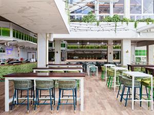 a restaurant with tables and chairs and plants at Crystalbrook Flynn in Cairns