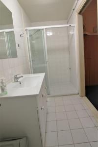a white bathroom with a shower and a sink at City East Motel in Melbourne
