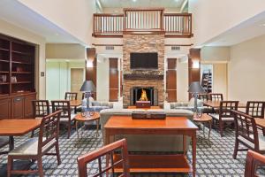 a hotel lobby with a fireplace and tables and chairs at Staybridge Suites Oklahoma City, an IHG Hotel in Oklahoma City