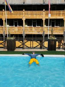 un hombre está flotando en una piscina en Shymbulak Resort Hotel, en Almaty