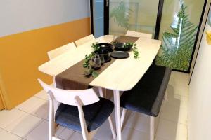 Kulai Dream Homestay 4room 16pax @near Kulai Aeon, JPO, Senai Airport, Legoland في كولايْ: طاولة غرفة طعام بيضاء مع كرسيين وطاولة