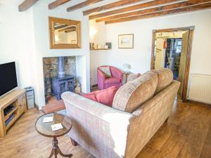 a living room with a couch and a tv at Ashknott Cottage in Ripon