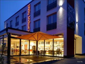 ein Hotel mit einem Sonnenschirm vor einem Gebäude in der Unterkunft CampusHotel in Hagen