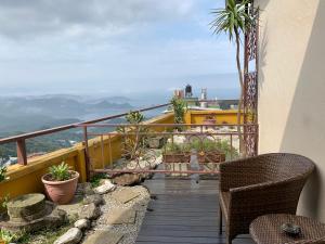 a balcony with chairs and a view of the mountains at Chiu Chunt Dint B&B in Jiufen