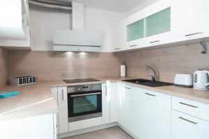 a kitchen with white cabinets and a stove top oven at Apartments Amavi in Izola