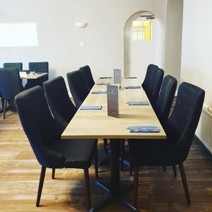 een conferentieruimte met een houten tafel en stoelen bij West End Hotel in Nairn