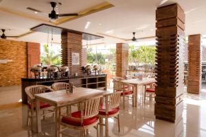 a restaurant with tables and chairs and a bar at Canggu Dream Village Hotel and Suites in Canggu