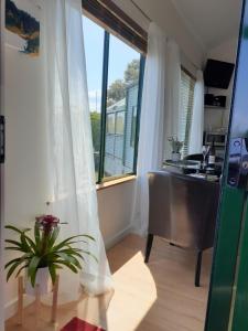 古尔瓦海雯木屋的客房设有窗户、书桌和桌子。