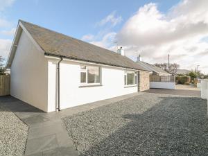 a white house with a driveway in front of it at Trem Y Garn in Pwllheli
