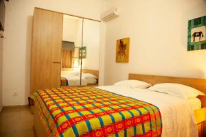 a bedroom with a large bed with a colorful blanket at Quintal di Maria in Guediawaye