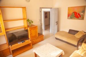 a living room with a tv and a couch at Quintal di Maria in Guediawaye