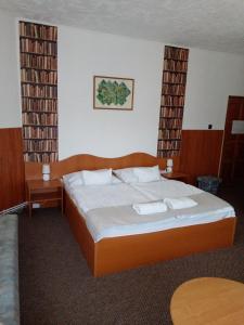 a bedroom with a large bed with two towels on it at Siesta Vendégház in Miskolctapolca