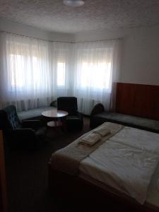 a hotel room with a bed and chairs and a table at Siesta Vendégház in Miskolctapolca