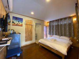 a bedroom with a bed and a television and a shower at Bed in Beyt Boutique Hotel in Nonthaburi
