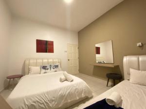 een hotelkamer met 2 bedden en een spiegel bij Arcadia Penang by Plush in George Town