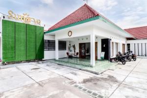 a house with a green and white facade at Hotel Sumaryo in Yogyakarta