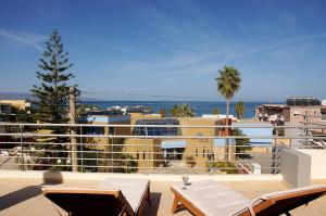 a balcony with a view of the ocean and buildings at Double View Apartment in Agia Marina Nea Kydonias
