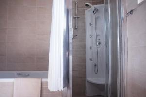 a bathroom with a shower and a bath tub at Double View Apartment in Agia Marina Nea Kydonias +32 photos