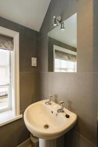 a bathroom with a sink and a mirror at The Old Custom House in Aldeburgh +16 photos
