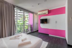 ein Schlafzimmer mit einem weißen Bett und einer rosa Wand in der Unterkunft CheQinn Hostel - Sukhumvit 4 Nana Plaza in Bangkok