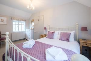 a bedroom with a large white bed with purple sheets at The Old Custom House in Aldeburgh