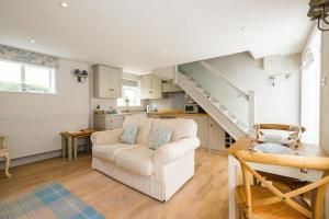 a living room with a white couch and a staircase at The Old Custom House in Aldeburgh