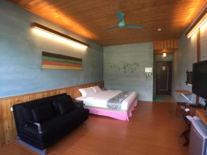 1 dormitorio con cama, sofá y TV en Ying Tian Ye Homestay, en Jian