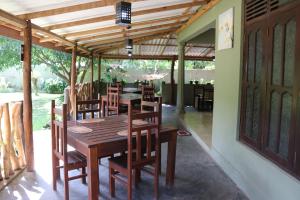 a dining room with a wooden table and chairs at Thal Sewana in Sigiriya