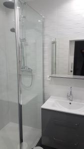 een badkamer met een glazen douche en een wastafel bij Hostellerie de la Crémaillère in Carnoux