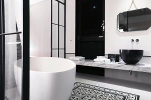 baño blanco con bañera y TV en Boutique Hotel Loft en Seúl