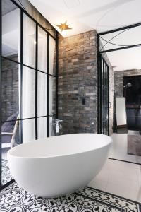 a large white bath tub in a room with windows at Boutique Hotel Loft in Seoul