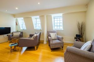 a living room with chairs and a flat screen tv at Seascape in Aldeburgh