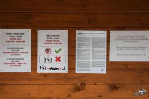a wall with signs on a wooden wall at "Rowerowa Przystań" turystyka wiejska & agroturystyka nad jeziorem Serwy w sercu Puszczy in Sucha Rzeczka